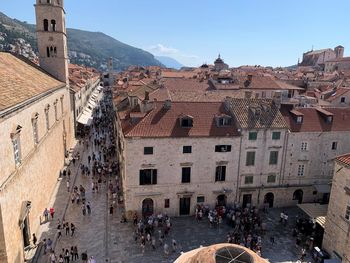 People at historic building in city against sky