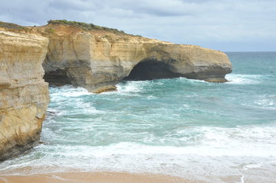 Rock formation in sea against sky