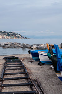 Boats moored on pier by sea against sky