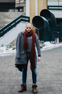 Full length portrait of man standing on footpath