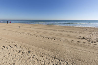 Scenic view of beach against clear blue sky