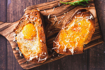 Close up of bread baked with egg and cheese on a cutting board top view