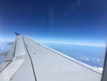 Airplane flying over mountain against sky