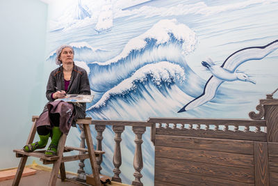 Woman sitting on railing