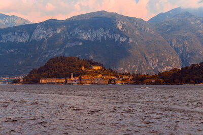 Scenic view of lake by mountains against sky