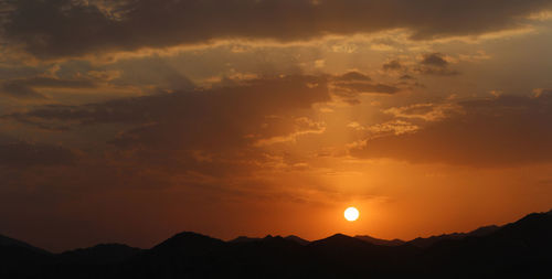 Scenic view of mountains against sky at sunset