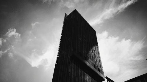 Low angle view of modern building against cloudy sky