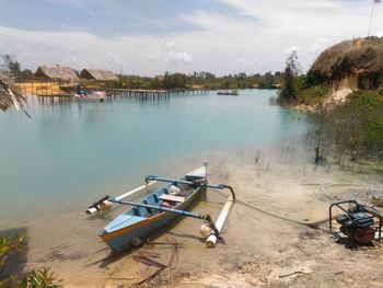 Boats moored on river against sky