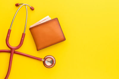 High angle view of eyeglasses on table against yellow background