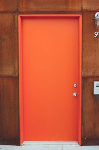 Closed orange door at corridor
