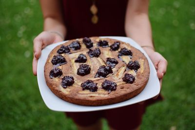 Midsection of woman holding tart on plate