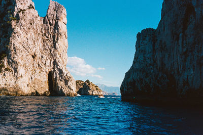 Scenic view of rock formation in sea against sky