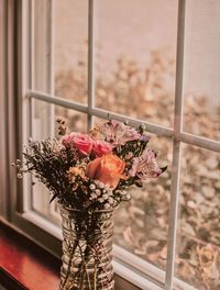 Close-up of flower vase against window