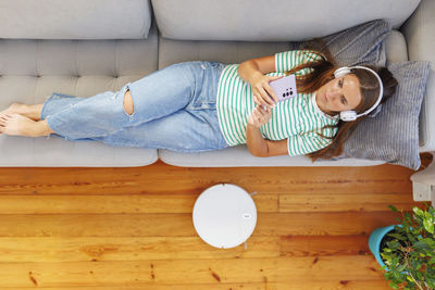 High angle view of cute baby boy sitting on sofa at home