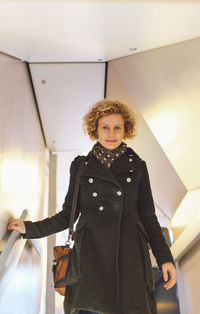 Portrait of woman standing in illuminated room