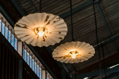 Low angle view of illuminated pendant light hanging from ceiling