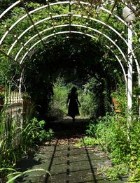 Rear view of woman standing in tunnel