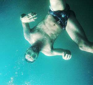 Shirtless man swimming in sea