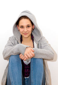 Portrait of smiling young woman against wall