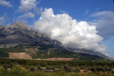 Scenic view of mountains against cloudy sky