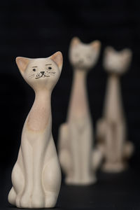 Close-up of figurine on table against black background