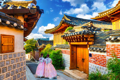 Rear view of woman outside temple against sky