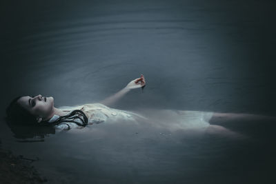 High angle view of woman lying in sea