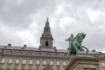 Low angle view of statue of building against cloudy sky