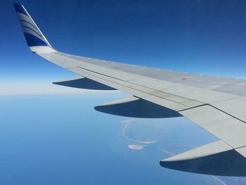 Cropped image of airplane flying over clouds