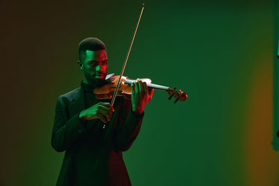 Cropped image of man playing violin against sky