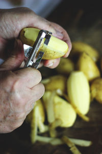 Close-up of man peeling potatoes