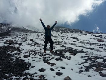 Full length of woman jumping on mountain