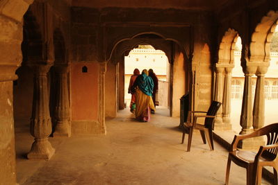 Rear view of women in corridor of building