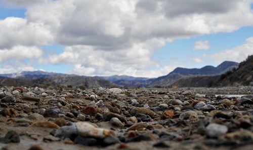 Surface level of stones on land against sky