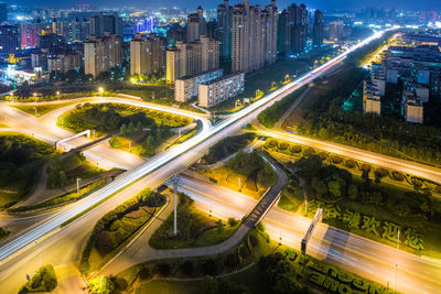 High angle view of illuminated street amidst buildings in city