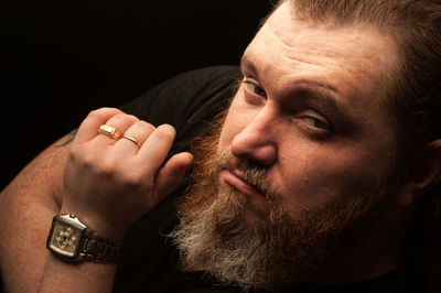 Close-up portrait of mid adult man over black background