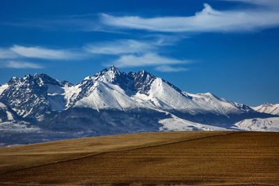 Scenic view of snowcapped mountain against cloudy sky