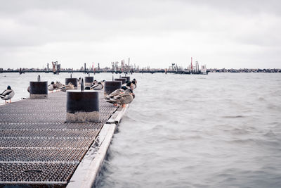 Pier over sea against sky in city
