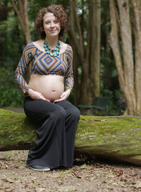 Pregnant modern young woman touching her belly outdoors.