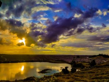 Scenic view of sea against dramatic sky during sunset