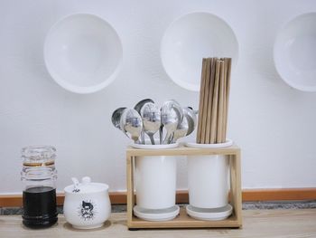 Close-up of spoons with chopsticks and plates in kitchen