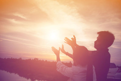 Rear view of silhouette man standing against sky during sunset