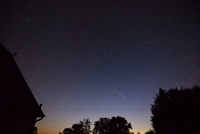Low angle view of silhouette trees against sky at night