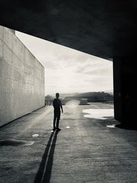 Rear view of man walking on road