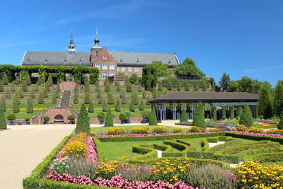 Built structure in garden by building against clear blue sky