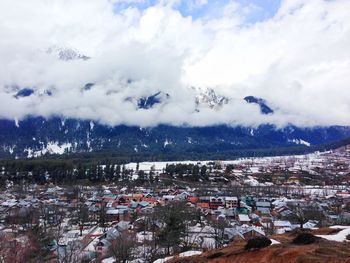 High angle view of houses on field against cloudy sky during winter