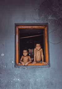 Portrait of a boy sitting on window