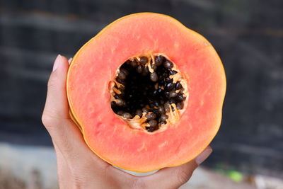 Close-up of hand holding orange