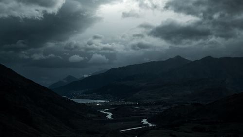 Scenic view of mountains against storm clouds