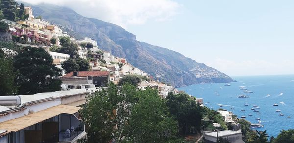 High angle view of townscape by sea against sky